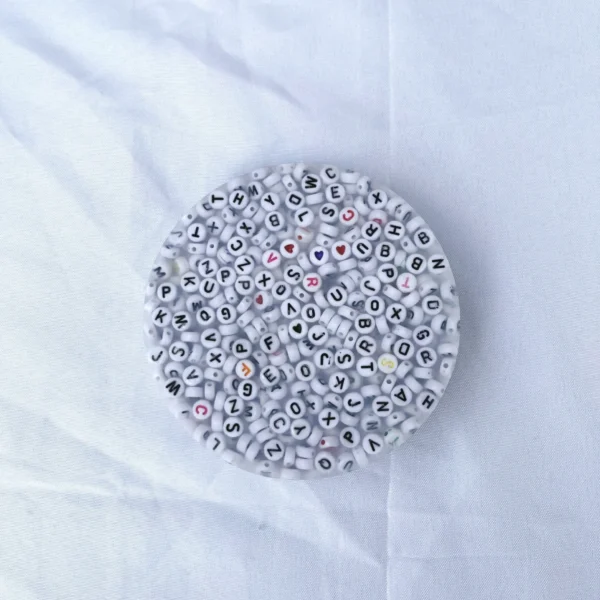 A picky pad filled with various white beads imprinted with letters and symbols