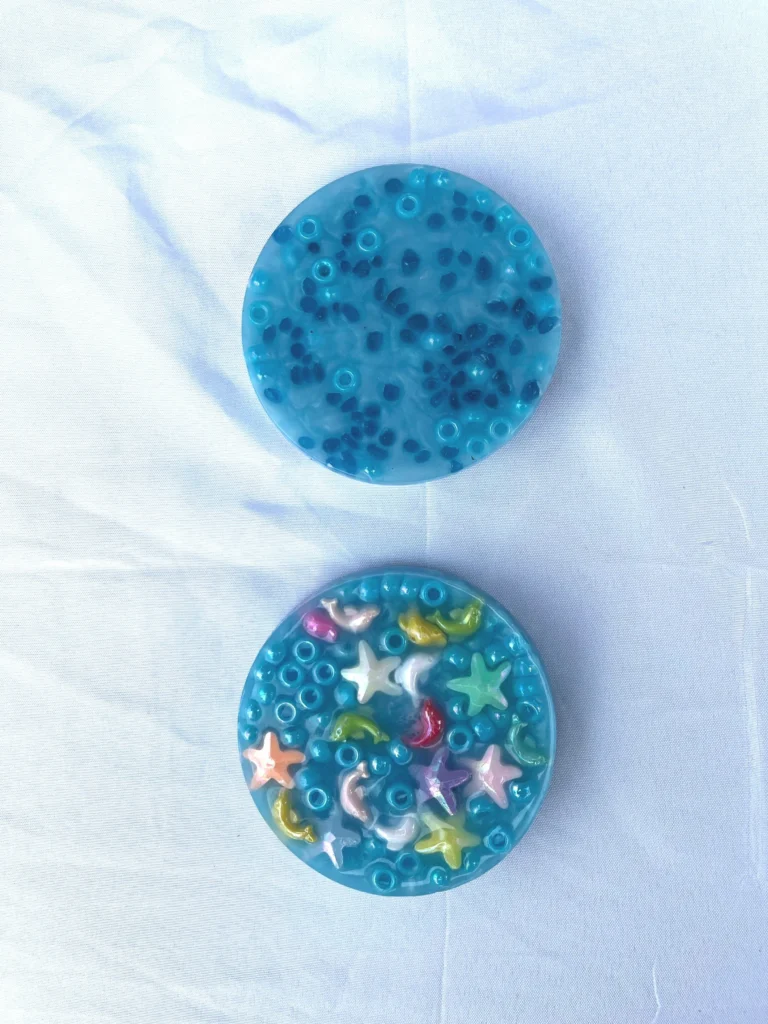 Two handmade picky pads made with aqua pony beads and mini sea creatures