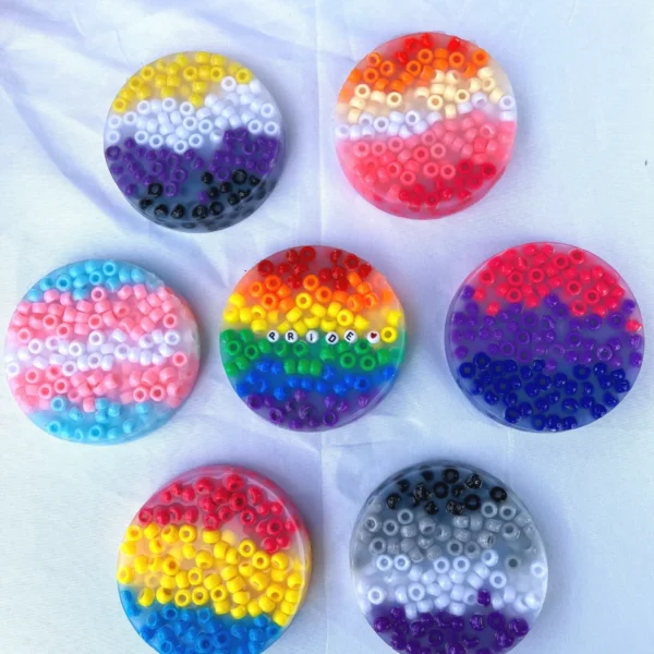7 picky pads, each made with different colored beads to represent the different flags of the LGBTQIA+ community