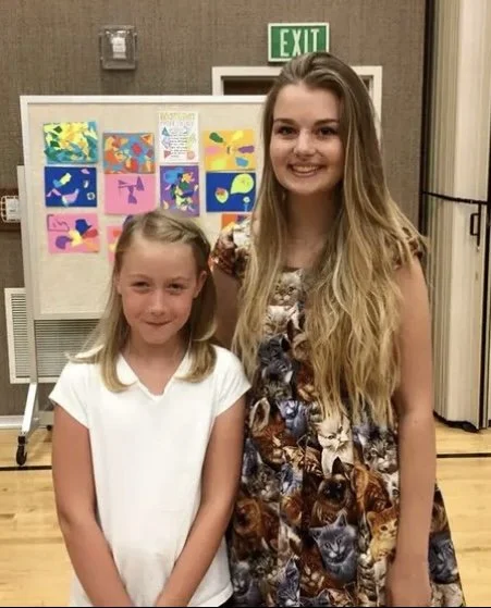Elise Jackman as a young adult in a gymnasium with one of her art students